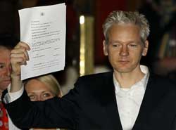 Julian Assange, centre, delivers a statement to the media outside the High Court, London